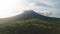 Aerial panorama of volcano erupt at sunrise. Nobody nature landscape. Sun rising over green plants