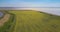 Aerial panorama yellow rape field and large lake in evening