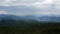 Aerial panoramic drone shot panning right to left of mountains with clouds