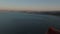 Aerial panoramic footage of large water surface and metropolis at dusk. Backwards reveal of top of large suspension
