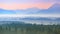 Aerial panoramic landscape of Alpine foggy foothills with morning sunrise over mountains