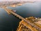 Aerial panoramic view of big river and transportation bridge over it with cars in autumn European city