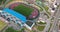 aerial panoramic view and circular flight near empty stadium or sports complex,