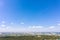 Aerial panoramic view of city residential area with buildings, forest and blue sky