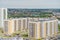 Aerial panoramic view dense of HDB apartment buildings at midday. High rises flat complex grass courtyard, green trees