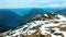 Aerial panoramic view of a flying paraglider of white colors parachutes from the snowy mountains in Austria. Beautiful views in th