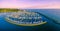 Aerial panoramic view of moored sailboats, breakwater, and Melbourne coastline at beautiful sunset.