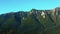 Aerial panoramic view of rocky mountains range. Video from drone flying over forested and cliffs slopes of Carpathian Mountains
