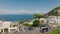 Aerial panoramic view of sea coast and majestic Mount Vesuvius in distance. Backwards reveal of houses in town. Capri