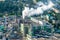 Aerial panoramic view on smoke pipes of a woodworking factory on the bank of a wide river