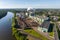 Aerial panoramic view on smoke pipes of a woodworking factory on the bank of a wide river