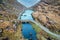 Aerial panoramic view of the stone Wishing Bridge over winding stream in green valley at Gap of Dunloe in Black Valley of Ring of
