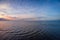 Aerial panoramic view of sunset over ocean. Nothing but sky, clouds and water