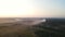 Aerial panoramic view of two windmill with rotating blades, working wind turbine among the woodlands at beautiful sunset