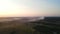 Aerial panoramic view of two windmill with rotating blades, working wind turbine among the woodlands at beautiful sunset