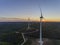 Aerial panoramic Wind farm turbines silhouette at sunset. Clean