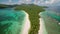 an aerial perspective of an island located in the middle of the vast ocean, Aerial view of small exotic beach surrounded by green