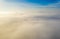 Aerial photo above the fog or white clouds with shining sun. Beautiful sunrise cloudy sky from aerial view. Above clouds from