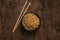 Aerial photo of freshly made ramen soup, served in a blue ceramic bowl, accompanied by chopsticks to consume it