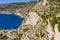 Aerial photo of man traveler on the cliff edge of beautiful and picturesque rocky coast close to Assos village on