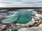 Aerial photo of one of the quartz quartz quartz quarry mining ponds with a suction dredger in the foreground and a dramatic sky.