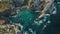 This aerial photo showcases a rocky coastline with clear blue water, Aerial shot of a radiant sea hugging a jagged coastline, AI