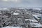 Aerial photo of a snowy day in the city of Leeds in the UK, showing rows of terrace houses with snow covered roofs in the Village