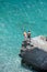 Aerial photo of two young boys on rock looking into sea