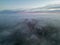Aerial photograph capturing the ethereal beauty of a city shrouded in mist during twilight