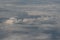 Aerial photograph of clouds outside of an airplane window while flying