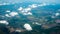 Aerial photograph of a pattern of fields, valleys and villages with cloud sky taken out of an aeroplane