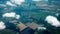 Aerial photograph of a pattern of fields, valleys and villages with cloud sky taken out of an aeroplane