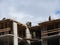 Aerial photograph of an unrecognized civil engineer without a face, watching the work of roof builders on the construction site.