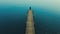 Aerial photography of a lone fisherman at the end of the wooden pier