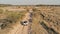 aerial picture of a desert steppe landscape with a 4x4 car approaching a small river stream