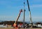 An aerial platform with a mobile crane install the first metal column of the new building