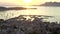 Aerial: port on tropical island with boats and ocean at small town at sunrise with mountains in background vacation