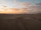 Aerial postcard panorama sunset view of buggy tour grop on dry sand dunes desert of Huacachina Ica Peru South America