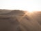 Aerial postcard panorama sunset view of isolated lonely single man person dry sand dunes desert of Huacachina Ica Peru