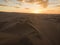 Aerial postcard panorama sunset view of isolated lonely single man person dry sand dunes desert of Huacachina Ica Peru