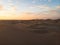 Aerial postcard panorama sunset view of isolated vast dry sand dunes desert of Huacachina Ica Peru South America