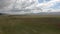 Aerial POV of dry farmland under cloudy sky