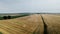 Aerial pullback shot over a wheat field Combine harvester harvesting