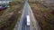 Aerial rear view of car overtaking truck with trailer on an interstate highway.