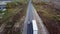 Aerial rear view of car overtaking truck with trailer on an interstate highway.