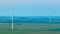 Aerial red lights on wind turbines at dusk on hazy evening over farmland