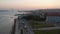 Aerial reveal of busy car traffic on the coast of Lisbon, Portugal with iconic red bridge Ponte 25 de Abril in the