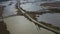 Aerial Reveal of exposed bridge in marshland, Narbonne, France