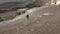 Aerial reverse view turn up happy couple tourist pair together running having fun on peak of White Rock surrounded by