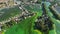 Aerial of river polluted with green algae with houses and boat docks on banks